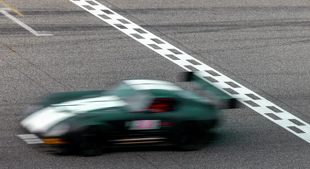 british racing green car past the line